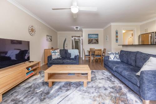 a living room with a couch and a table at Wallis Gardens 11 in Forster
