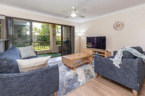 a living room with two couches and a tv at Wallis Gardens 11 in Forster