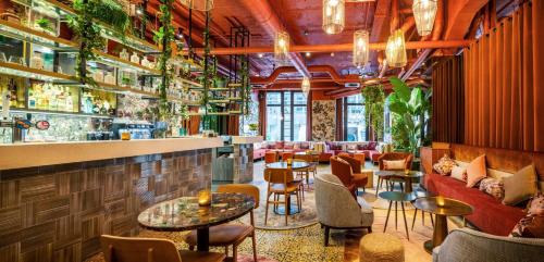 a restaurant with a bar with tables and chairs at Hotel Indigo Brussels - City by IHG in Brussels