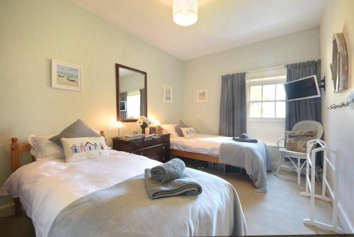a bedroom with two beds and a mirror at Craster Tower Penthouse in Craster