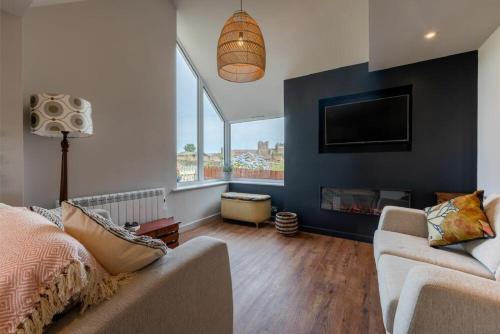 a living room with a couch and a tv at Castle View Bamburgh in Bamburgh