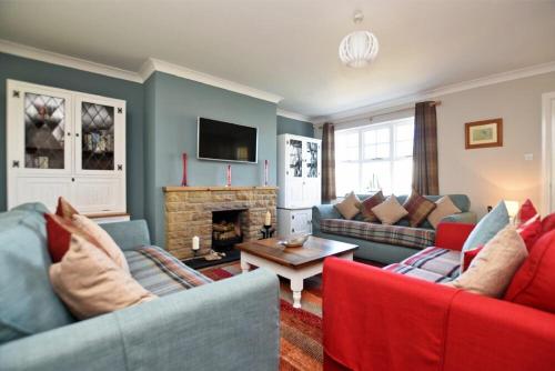 a living room with two couches and a fireplace at Armstrong Cottages No22 in Bamburgh