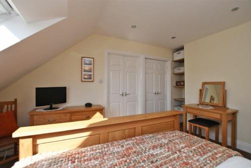 a bedroom with a bed and a desk with a television at Armstrong Cottages No22 in Bamburgh