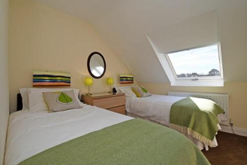 a attic bedroom with two beds and a window at Armstrong Cottages No22 in Bamburgh