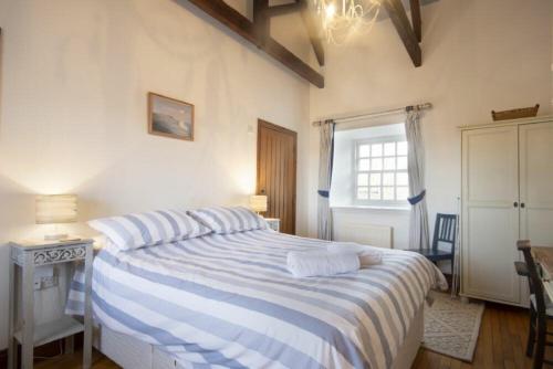 a bedroom with a large bed with blue and white stripes at No9 Budle Sands in Bamburgh