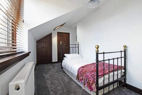 een slaapkamer met een bed en een raam bij Beach Retreat in Seahouses
