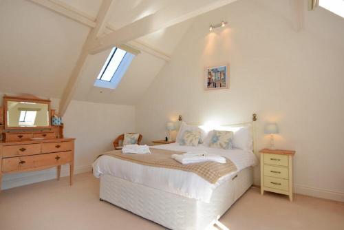 a bedroom with a bed and a dresser and a mirror at Croft Cottage Alnwick in Alnwick