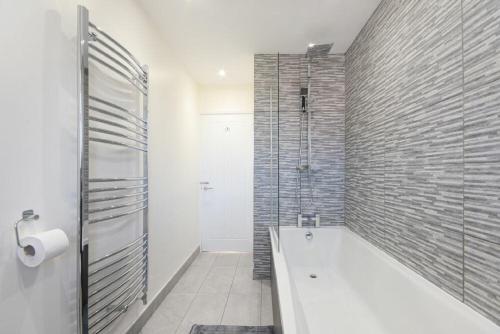 a bathroom with a bath tub and a shower at Rivershield in Warkworth