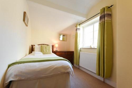 a bedroom with a bed and a window and a tub at Castle View Warkworth in Warkworth