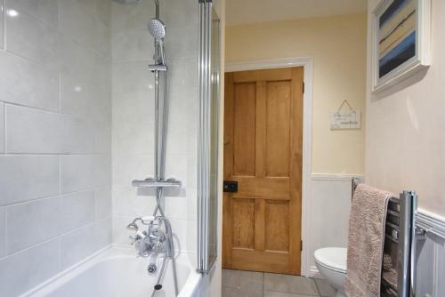 a bathroom with a shower and a tub and a toilet at Castle View Warkworth in Warkworth