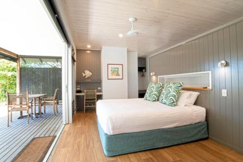 a bedroom with a bed and a dining room at The Bungalows in Mission Beach