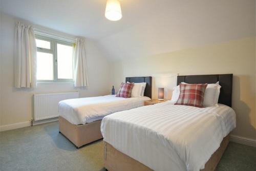 a bedroom with two beds and a window at Annstead House in Seahouses