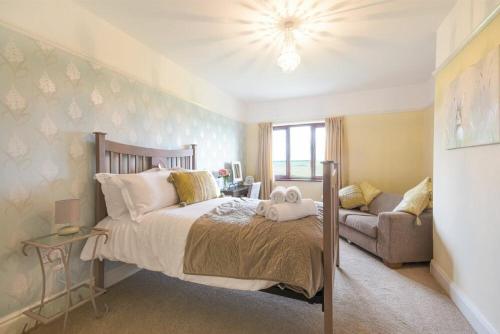 Dairyman's Cottage في آمبل: غرفة نوم بسرير كبير وأريكة
