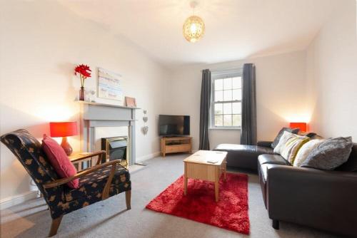 a living room with a couch and a fireplace at Church View in Bamburgh