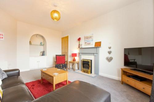 a living room with a couch and a fireplace at Church View in Bamburgh