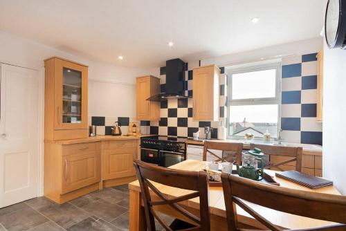 a kitchen with a table and chairs and a stove at Church View in Bamburgh