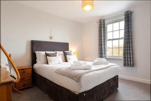 a bedroom with a large bed with two towels on it at Church View in Bamburgh