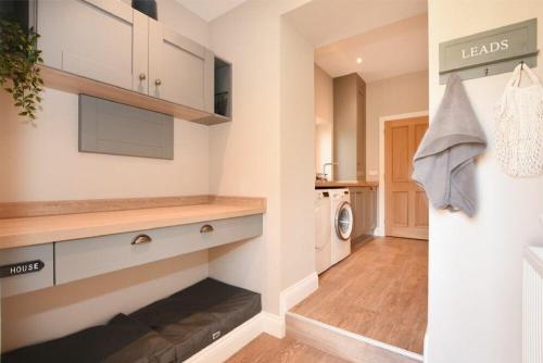 a kitchen with white cabinets and a washer and dryer at Bradacar in Seahouses
