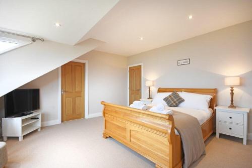 a bedroom with a large bed and a television at Bradacar in Seahouses