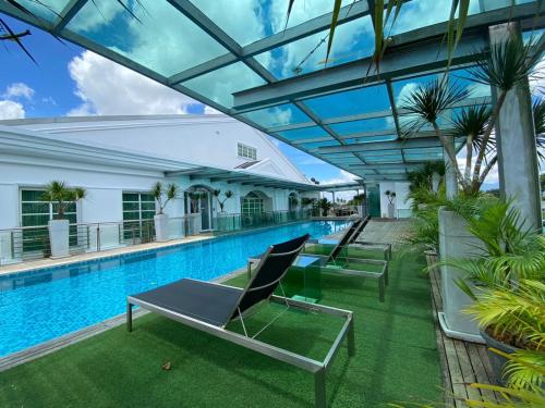 a swimming pool with lounge chairs in a building at Wesberly Apartments in Kuching