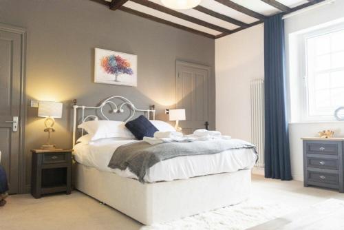 a bedroom with a white bed and a window at Treetops, Alnwick in Alnwick