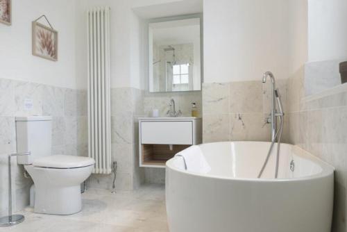 ein Badezimmer mit einer Badewanne, einem WC und einem Waschbecken in der Unterkunft Treetops, Alnwick in Alnwick