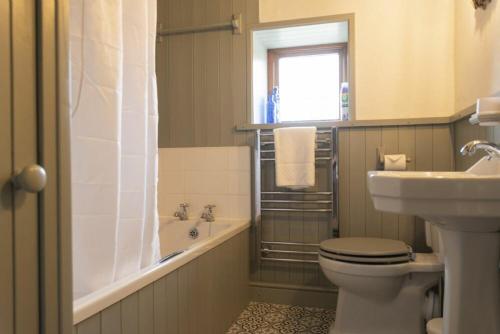 ein Badezimmer mit Toilette, Waschbecken und Badewanne in der Unterkunft Kittiwake Cottage, Seahouses in Seahouses