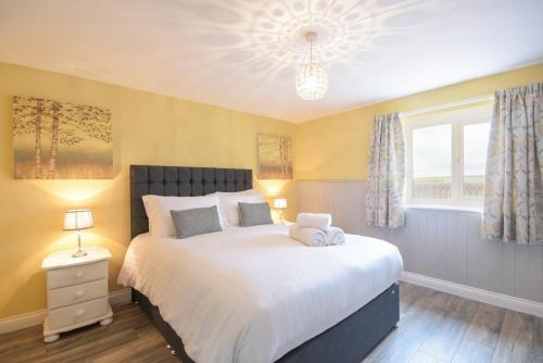a bedroom with a large bed and a window at Dairymaid's Cottage in Amble