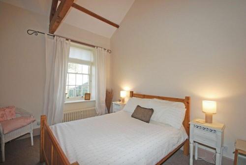 a bedroom with a bed and a window at Apple Orchard House in Alnmouth