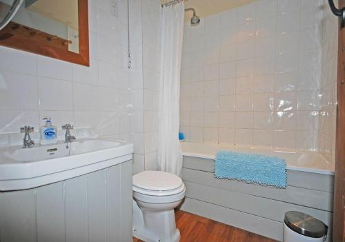 a bathroom with a toilet and a sink and a tub at Apple Orchard House in Alnmouth