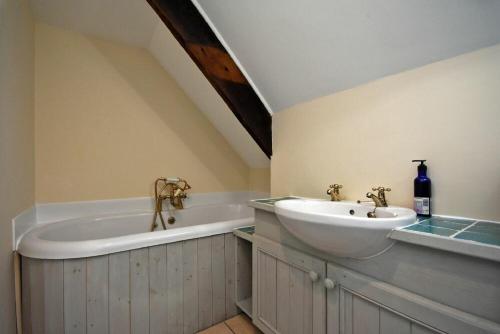 a bathroom with a sink and a bath tub at Pebble Cottage in Long Houghton