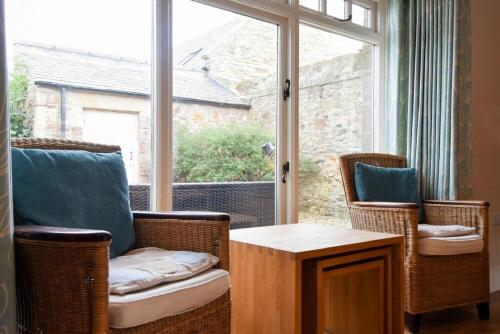 a living room with chairs and a large window at High Tide in Newton by the Sea