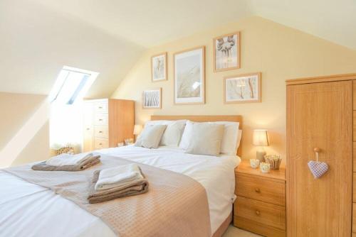 a bedroom with a large bed with towels on it at Lavender Cottage Village Farm in Seahouses