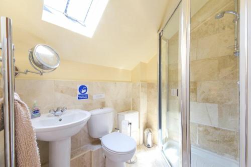 a bathroom with a toilet and a sink and a shower at Lavender Cottage Village Farm in Seahouses