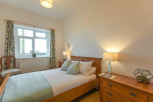 a bedroom with a bed and a window at Bellshill Cottage in Belford