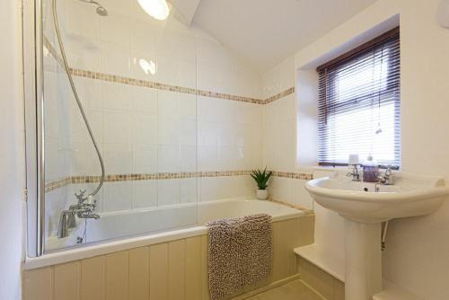 a bathroom with a sink and a bath tub and a sink at Bellshill Cottage in Belford