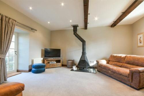 a living room with a couch and a fireplace at Budle Granary in Bamburgh