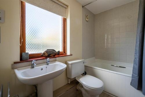 a bathroom with a sink and a toilet and a window at Fidra in Embleton