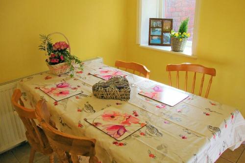 a table with a table cloth with flowers on it at Briar Cottage in Wark
