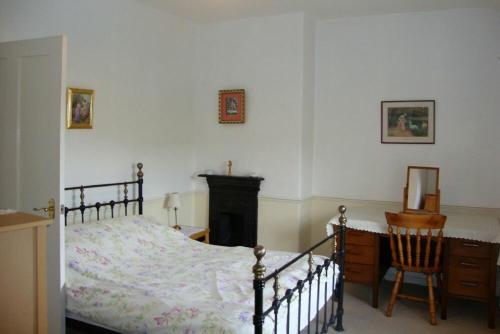a bedroom with a bed and a desk and a chair at Briar Cottage in Wark