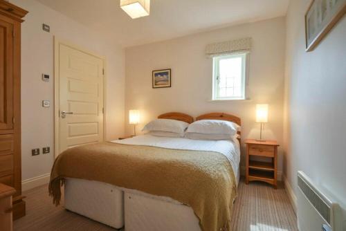 1 dormitorio con 1 cama con 2 almohadas y ventana en Northrawe, en Bamburgh
