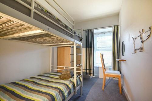 a bedroom with a bunk bed and a chair at Crier Cottage in Alnwick