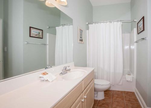 uma casa de banho branca com um lavatório e um WC em Crystal Shores 204 em Gulf Shores