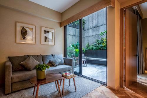 a living room with a couch and a large window at Ana Polanco Apartments in Mexico City