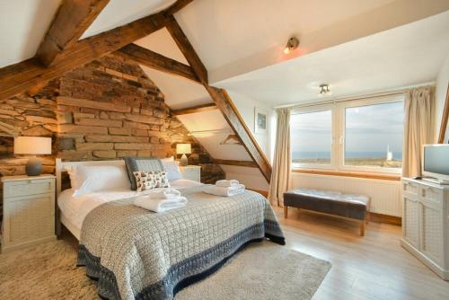 a bedroom with a bed and a stone wall at Farne Lookout in Seahouses