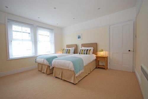 a bedroom with a large bed and two windows at Coastal Haven in Seahouses