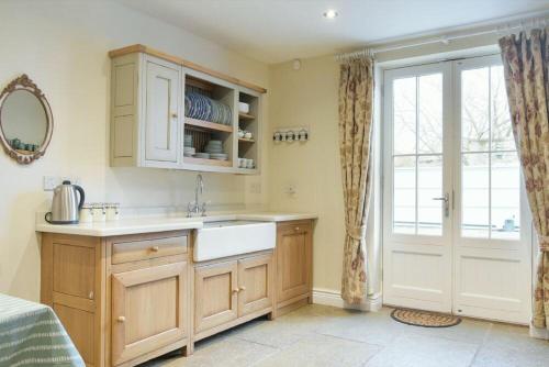 a kitchen with a sink and a counter with a window at Charlton Cottage in Bamburgh