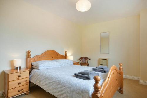 1 dormitorio con cama de madera y tocador de madera en Decked Out, en Alnmouth