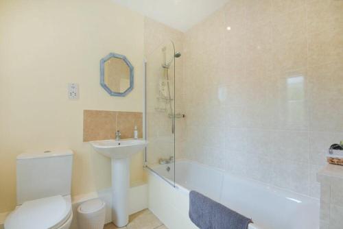 a bathroom with a toilet and a sink and a shower at Decked Out in Alnmouth