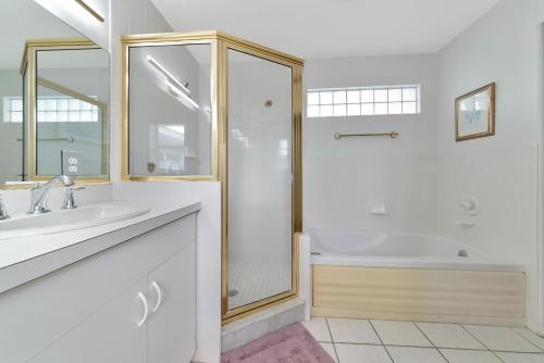 a white bathroom with a shower and a sink at Siesta-Retreats - Key West Unit in Siesta Key